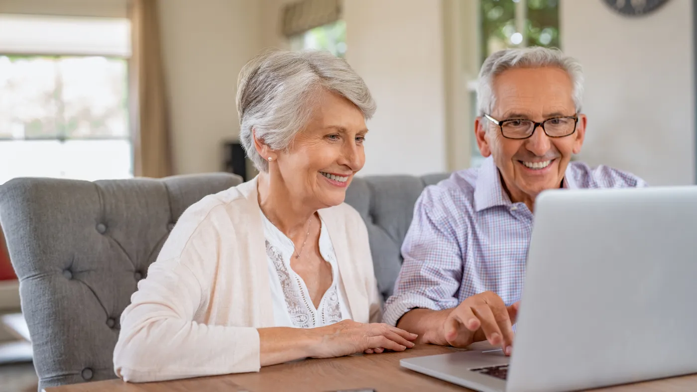 Grandparents watching district video on a laptop at home