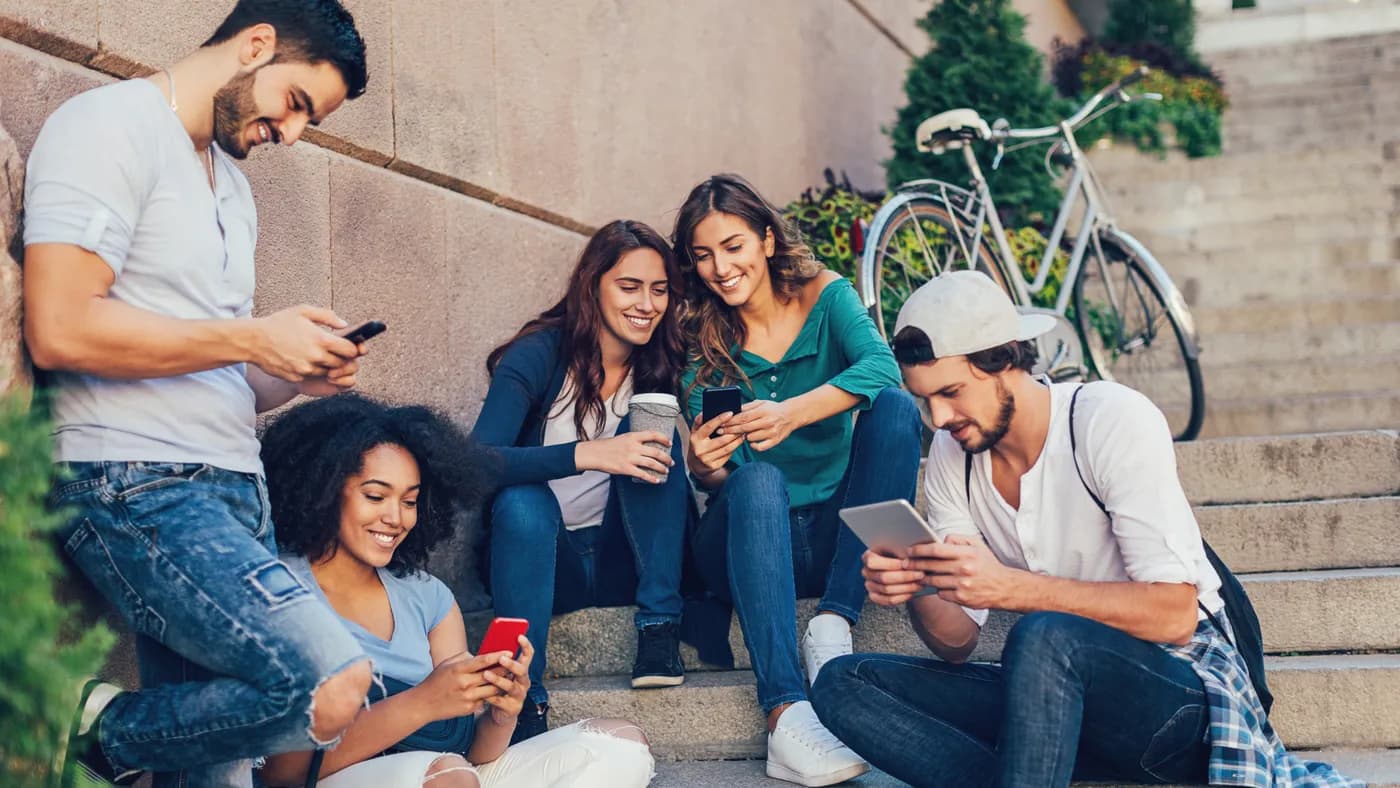 Students watching video together on their phones and a tablet