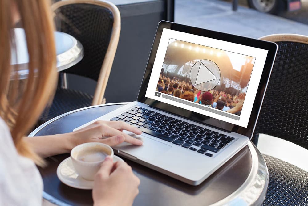 A viewer watching an on-demand program on a laptop.