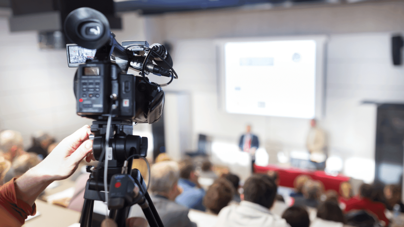 A production camera covers a televised public meeting
