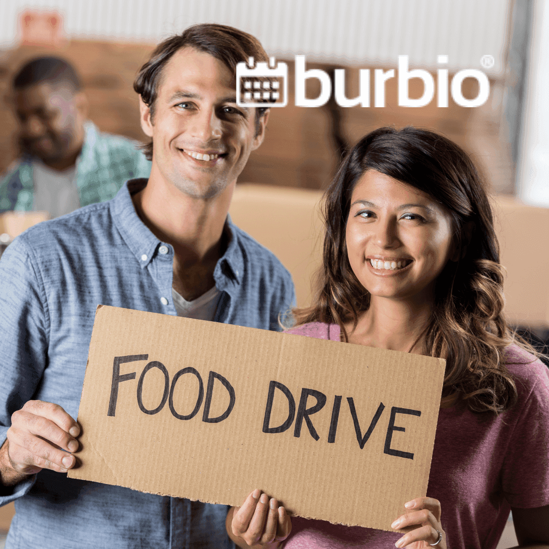 Two people hold a 'Food drive' cardboard sign