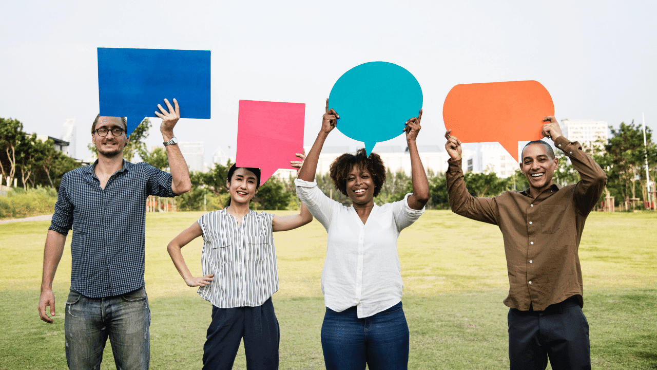 Four people holding conversation bubble signs
