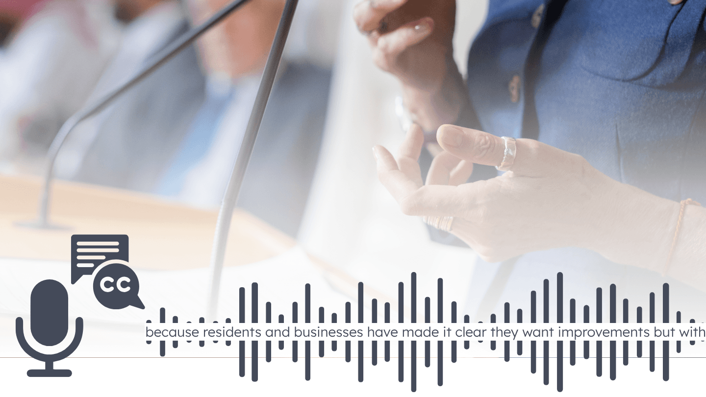Close-up of a person speaking at a podium with microphones. Overlaid are icons for captions and audio, with a transcript excerpt and waveform, representing AI caption accuracy.