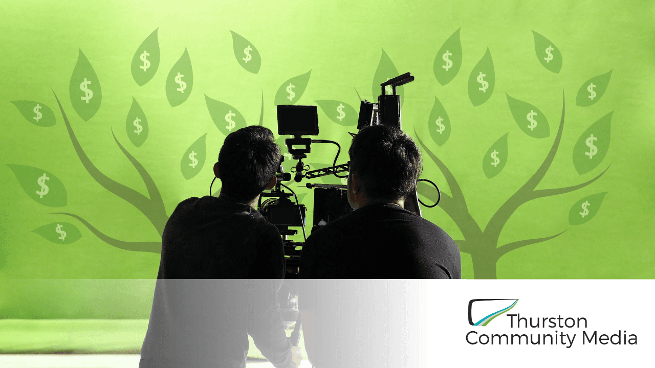 Two people using video equipment, with a money tree in the background
