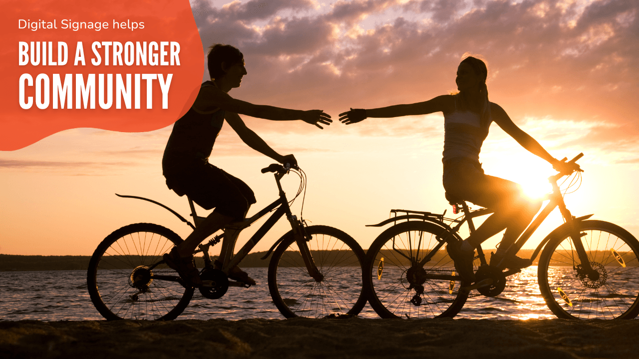 Two people riding bicycles in the sunset, reaching to grab hands