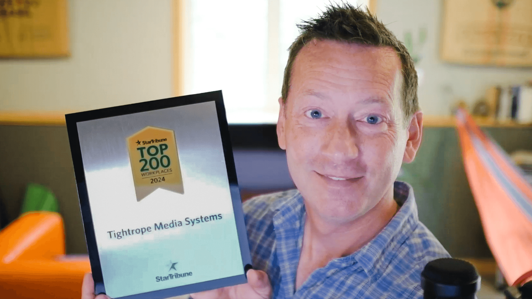 JJ Parker, CEO of Tightrope Media Systems, proudly holding the Star Tribune Top 200 Workplaces 2024 award plaque.