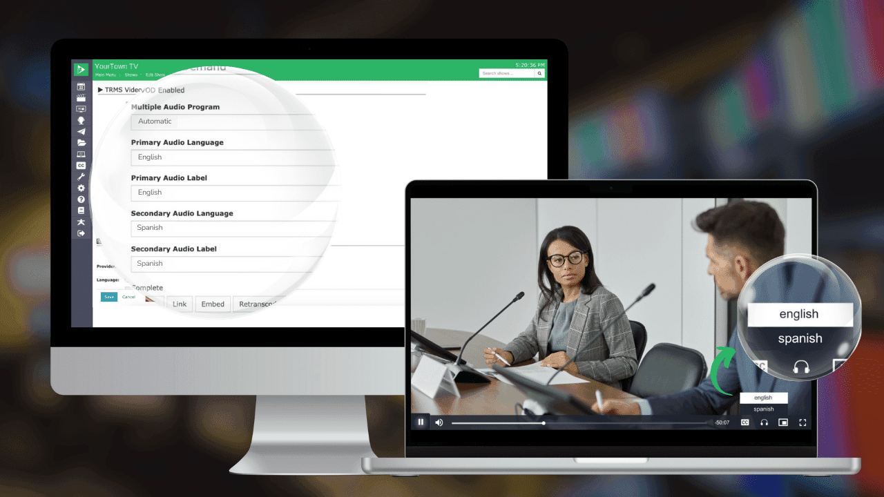 The image shows a two-monitor setup. On the left monitor, a software interface for "YourTown TV" is open, displaying settings for a Multiple Audio Program. It indicates a "Primary Audio Language" set to English with a corresponding label, and a "Secondary Audio Language" set to Spanish, also with a corresponding label. On the right monitor, there's a video playback showing a professional setting with two people: a woman seated at a desk, looking at a man who is turned towards her. The woman is wearing glasses and a formal blazer, indicating a business or formal event. The video player interface includes a graphic allowing the user to switch between English and Spanish audio, with a circular toggle featuring the two languages.